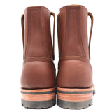 A pair of brown leather lace-up ankle boots shown from the back, featuring stacked rubber soles with a black tread and a tan mid-layer, set against a plain white background.