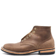 A brown leather lace-up ankle boot with brass eyelets, white contrast stitching, and a stacked black and tan sole, shown from a side profile on a white background.