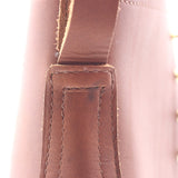 Close-up detail of a brown leather strap and stitched leather tab on a boot. Visible scorch mark under the pull loop.