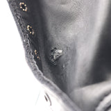 Close up of the gusset of a leather boot showing visible hole in the gusset leather. Hole has been patched with glue, but is visible.