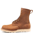 Tall brown leather boot with brass hardware, a rear pull loop, and white wedge outsole in front of a white background.