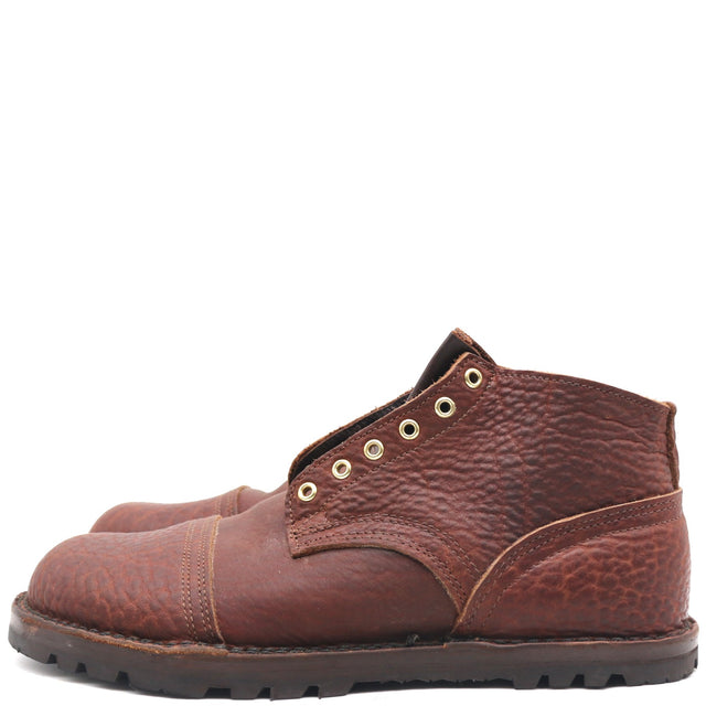 A pair of brown textured leather lace-up ankle boots with brass eyelets and a rugged dark sole, shown from a side profile on a white background.