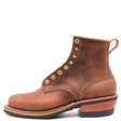 A brown leather lace-up ankle boot with brass eyelets, a stacked wood-look heel, and a black outsole, shown from a side profile on a white background.