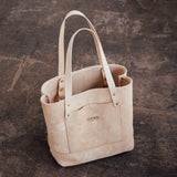 Veg Tan Suede Tote sitting on textured concrete